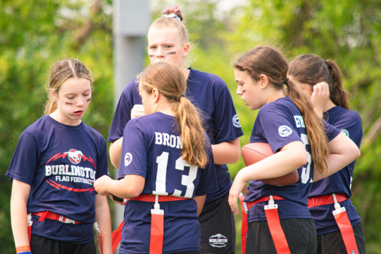 Girls flag football team huddling at provincials
