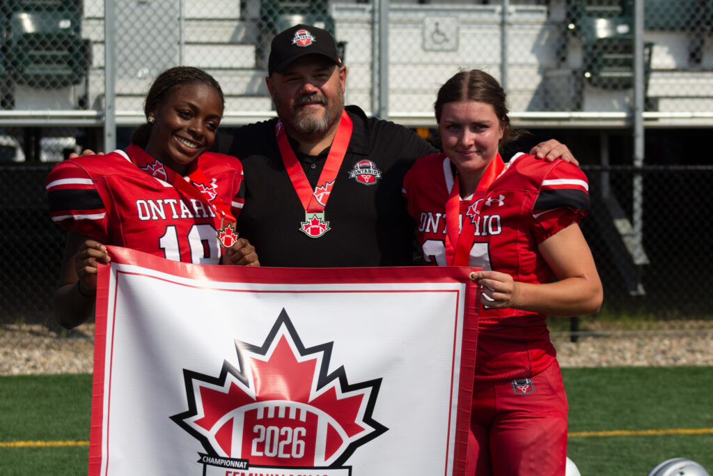 Team Ontario U18 Women’s Tackle coach celebrating the 2026 national championship with players